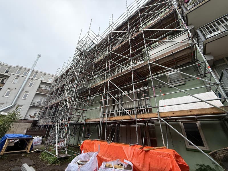 Achtergevel van een Amsterdams pand in de steiger voor gevelrenovatie en stucwerk
