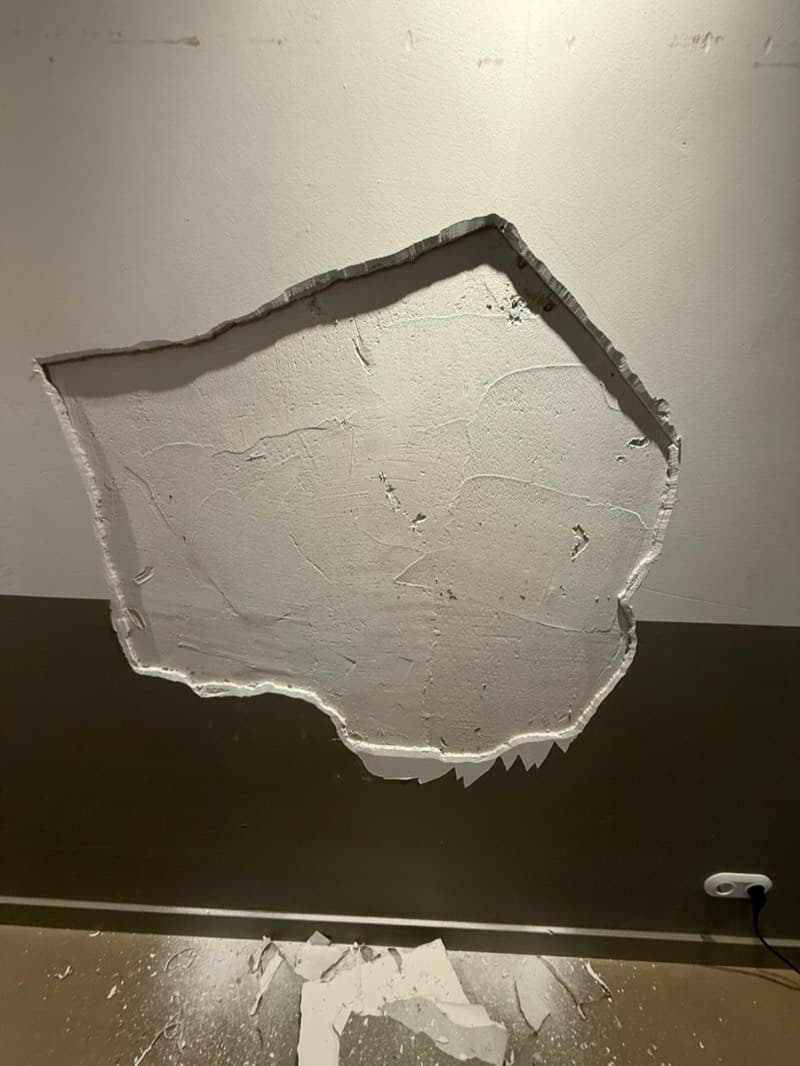Grote plaat stucwerk losgelaten van een muur in Amsterdam