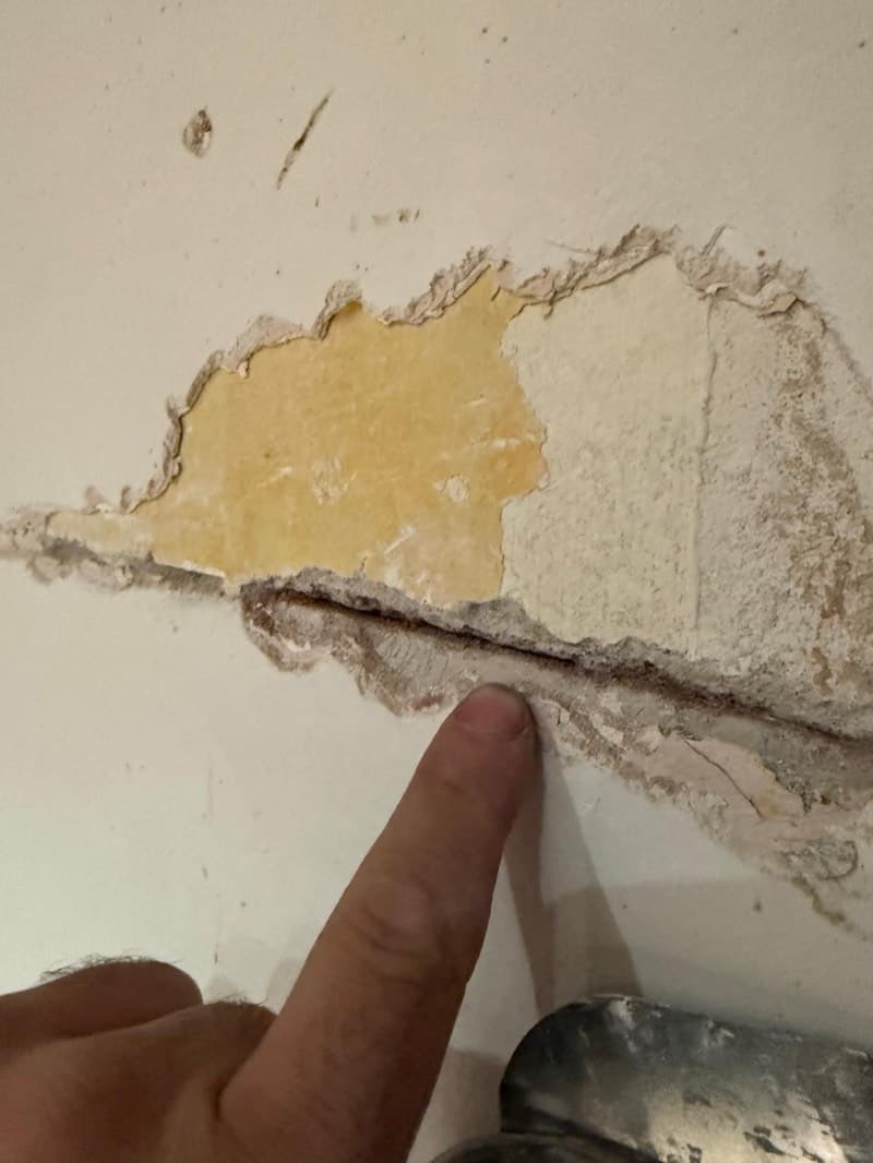 Vochtschade in een Amsterdams grachtenpand — stucwerk laat los van het metselwerk