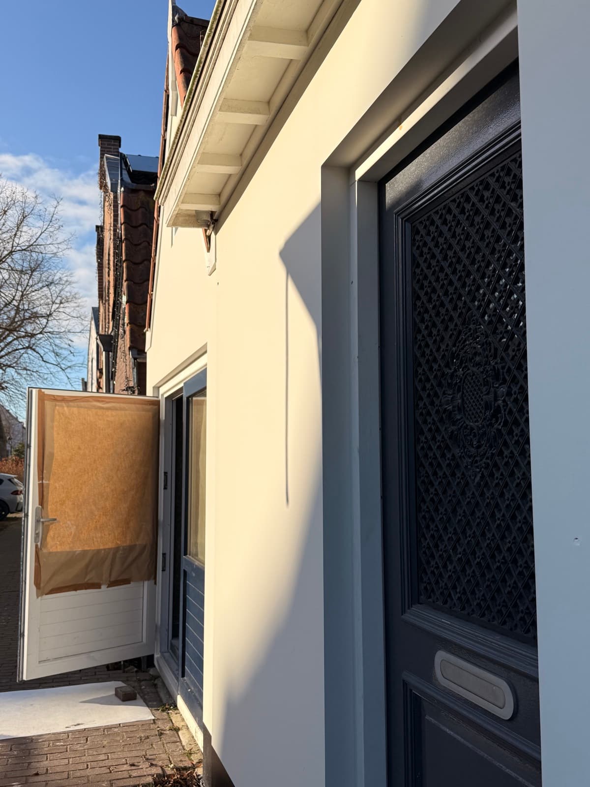 Glad gevelstucwerk met voordeur en strijklicht