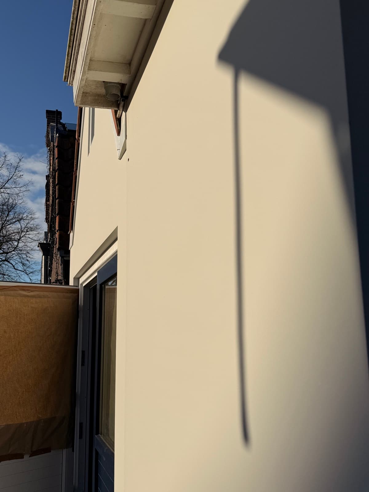 Close-up glad gevelstucwerk met zonlicht schaduwlijn