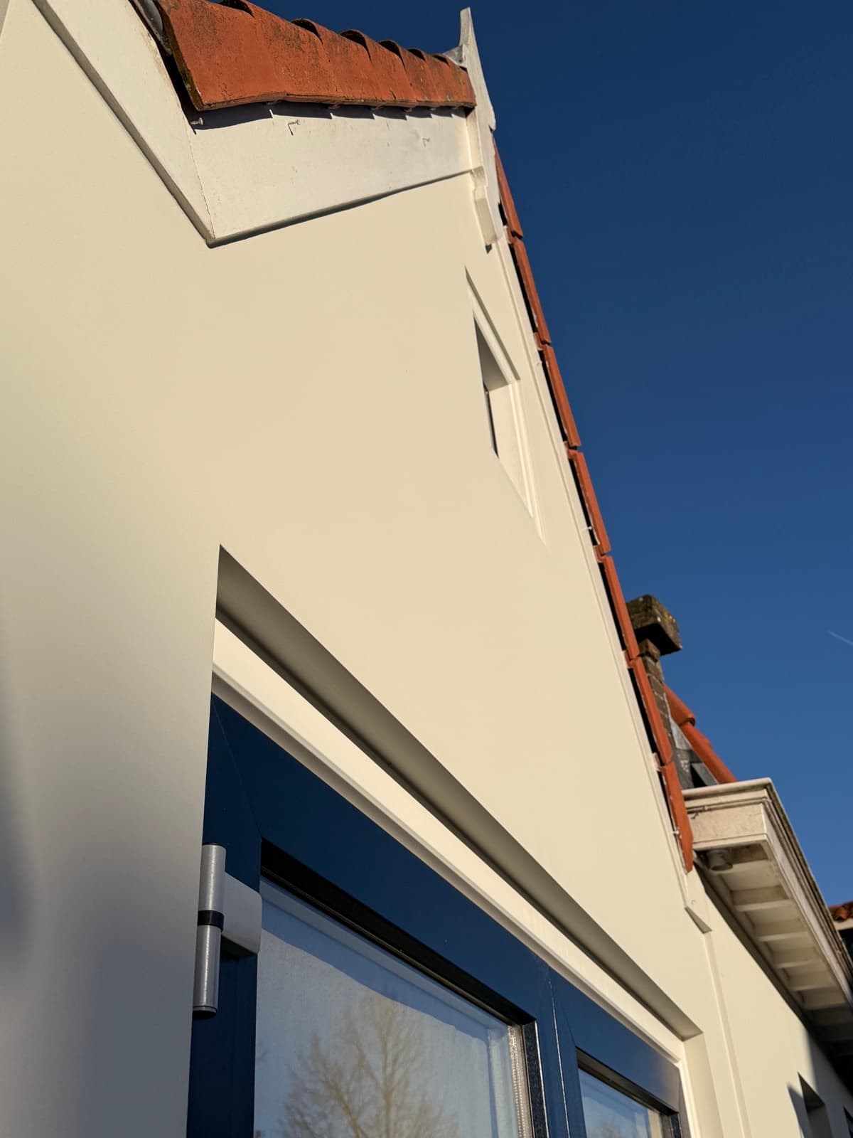 Glad gevelstucwerk met strijklicht van de zon op de gevel