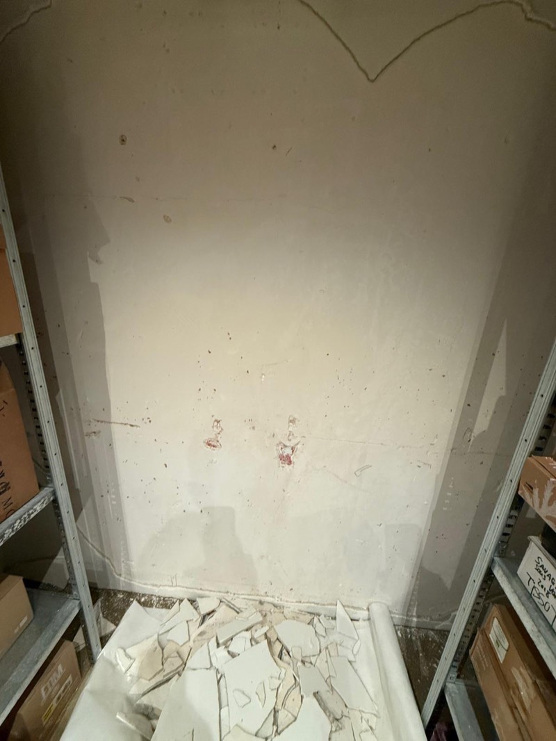 Vochtschade in een souterrain van een Amsterdams pand — stucwerk afgebladderd en op de grond gevallen